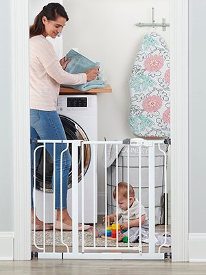 Regalo Easy Step walk-through baby gate installed in a doorway near stairs with white metal frame