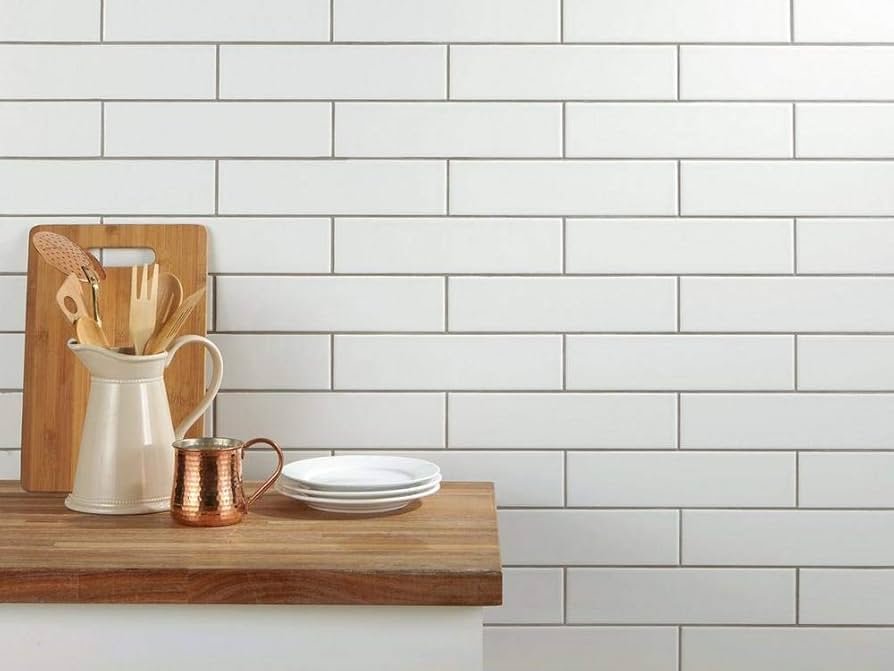 White ceramic subway tile backsplash installed behind stove in modern kitchen