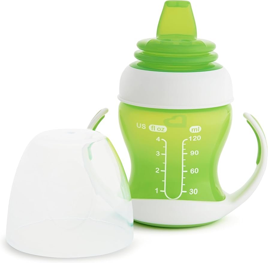 Munchkin gentle transition trainer cup 4 ounce size, green cup with handles on a high chair tray