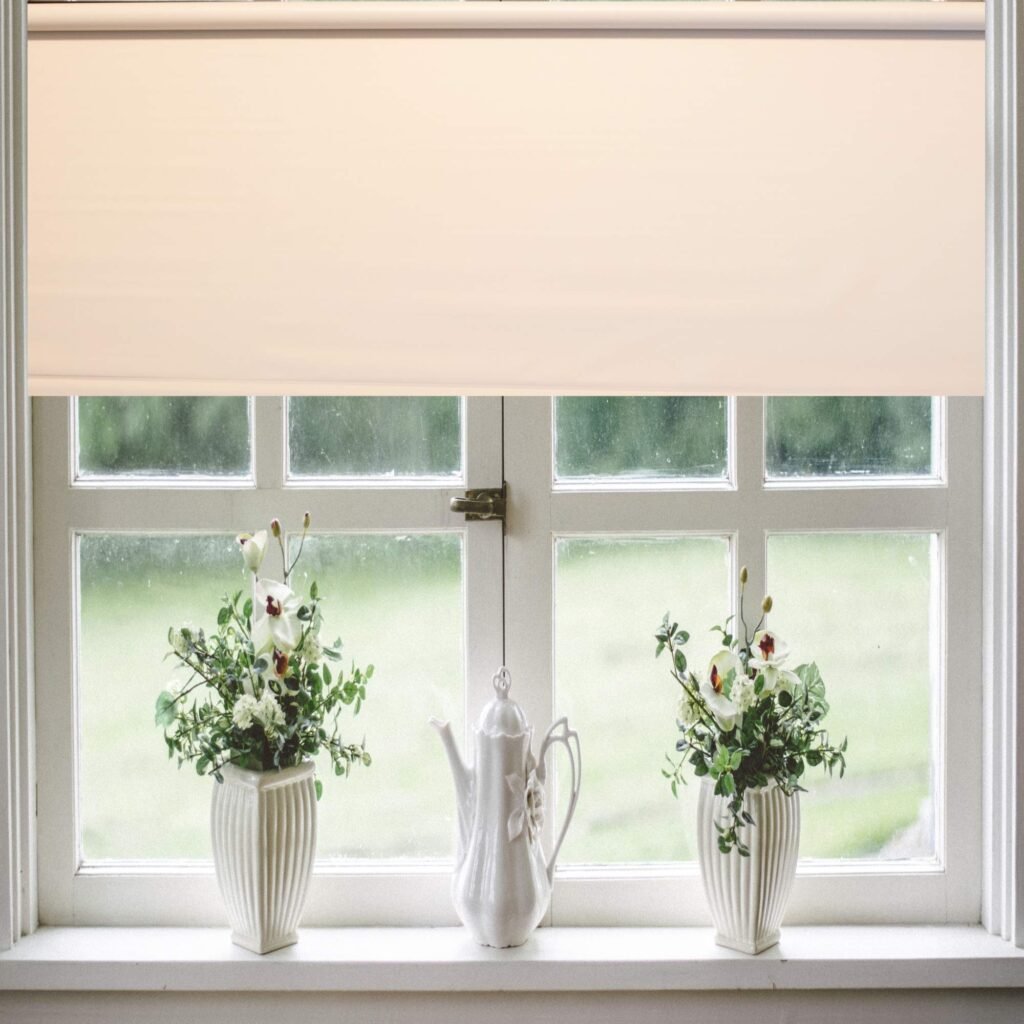 White vinyl roller shade covering a frosted bathroom window