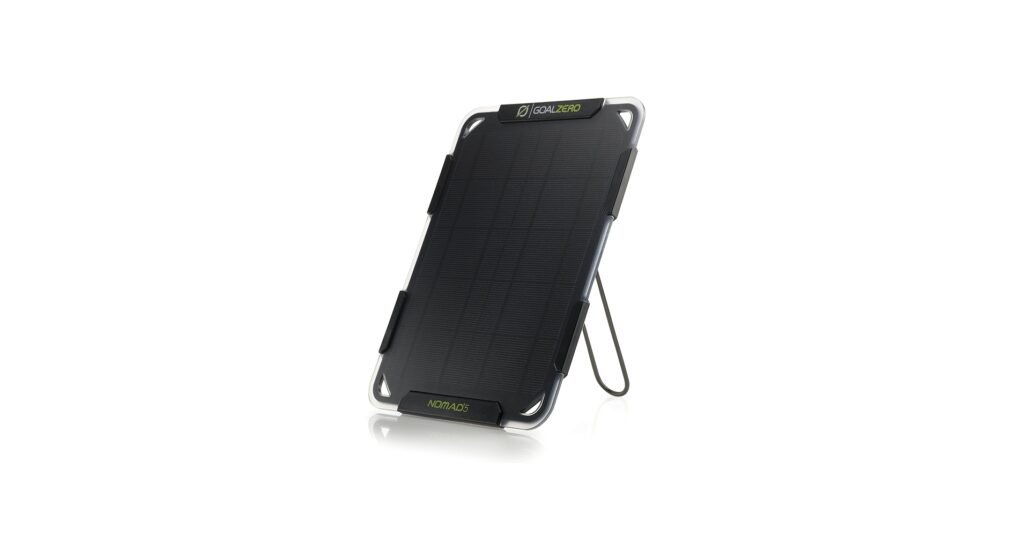 Goal Zero Nomad 5 small solar panel propped up with kickstand, charging a phone outdoors