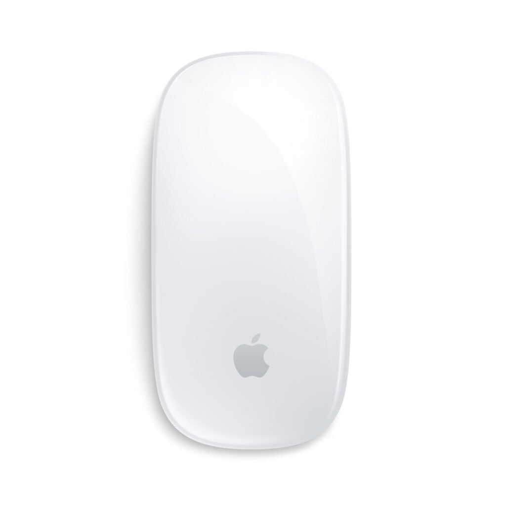 Apple Magic Mouse next to a MacBook on a clean desktop