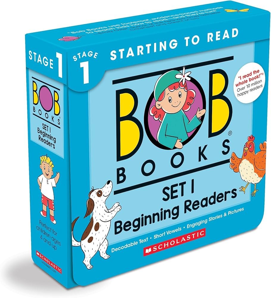 Child reading Bob Books Set 1 at a table with simple phonics pages and large print