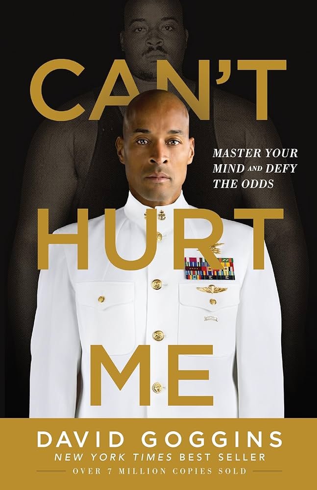 “Can't Hurt Me” book cover shown beside a notepad, representing the best self-help books for men focused on mental toughness.