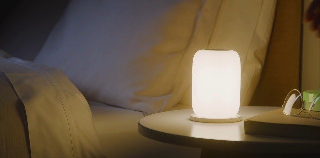 Warm-glow bedside nightlight creating a soft amber pool of light for adult sleep routines.