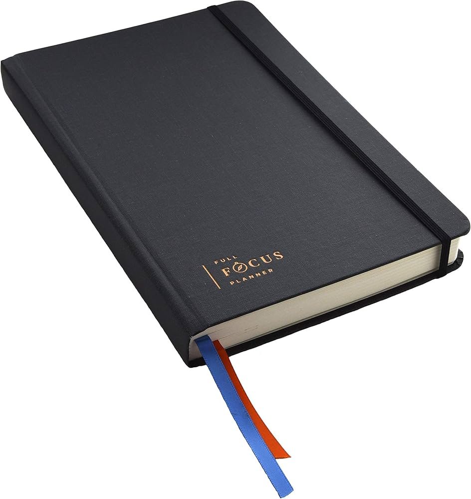 Full Focus Planner open to a daily page highlighting top three priorities.