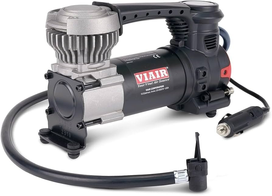 VIAIR 84P portable air compressor for car tires with heavy-duty hose and battery clamp power connection.