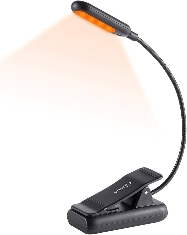 Amber rechargeable book light for reading in bed with multiple brightness levels and color settings for a softer night setup.